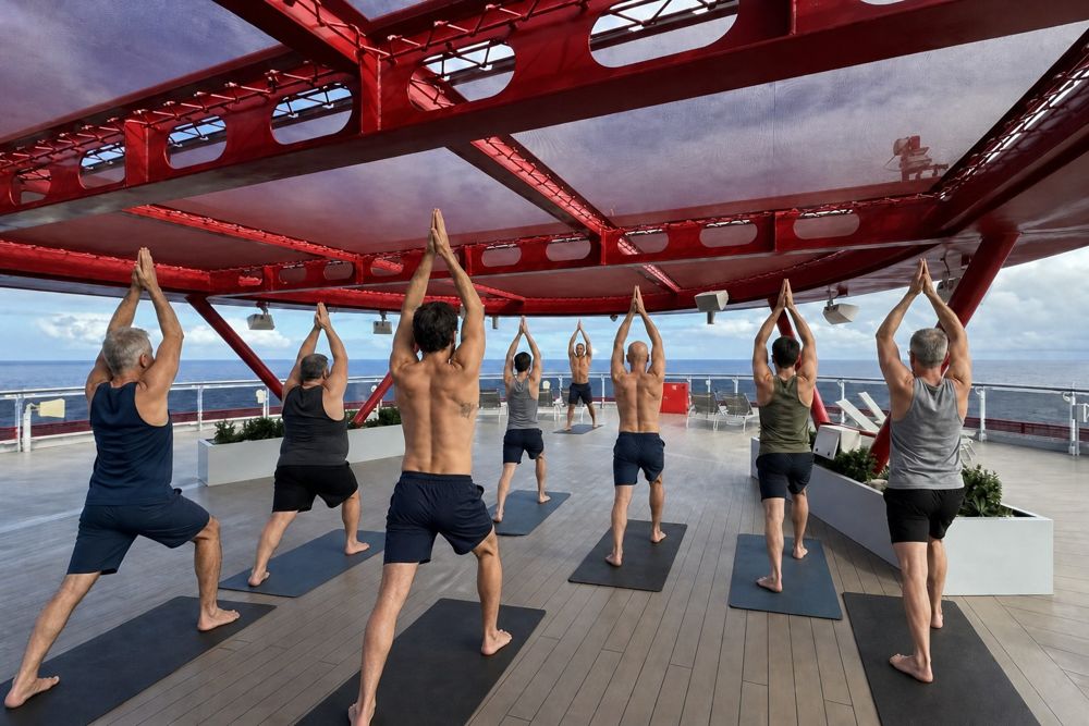 A group practicing yoga together on an open ship deck