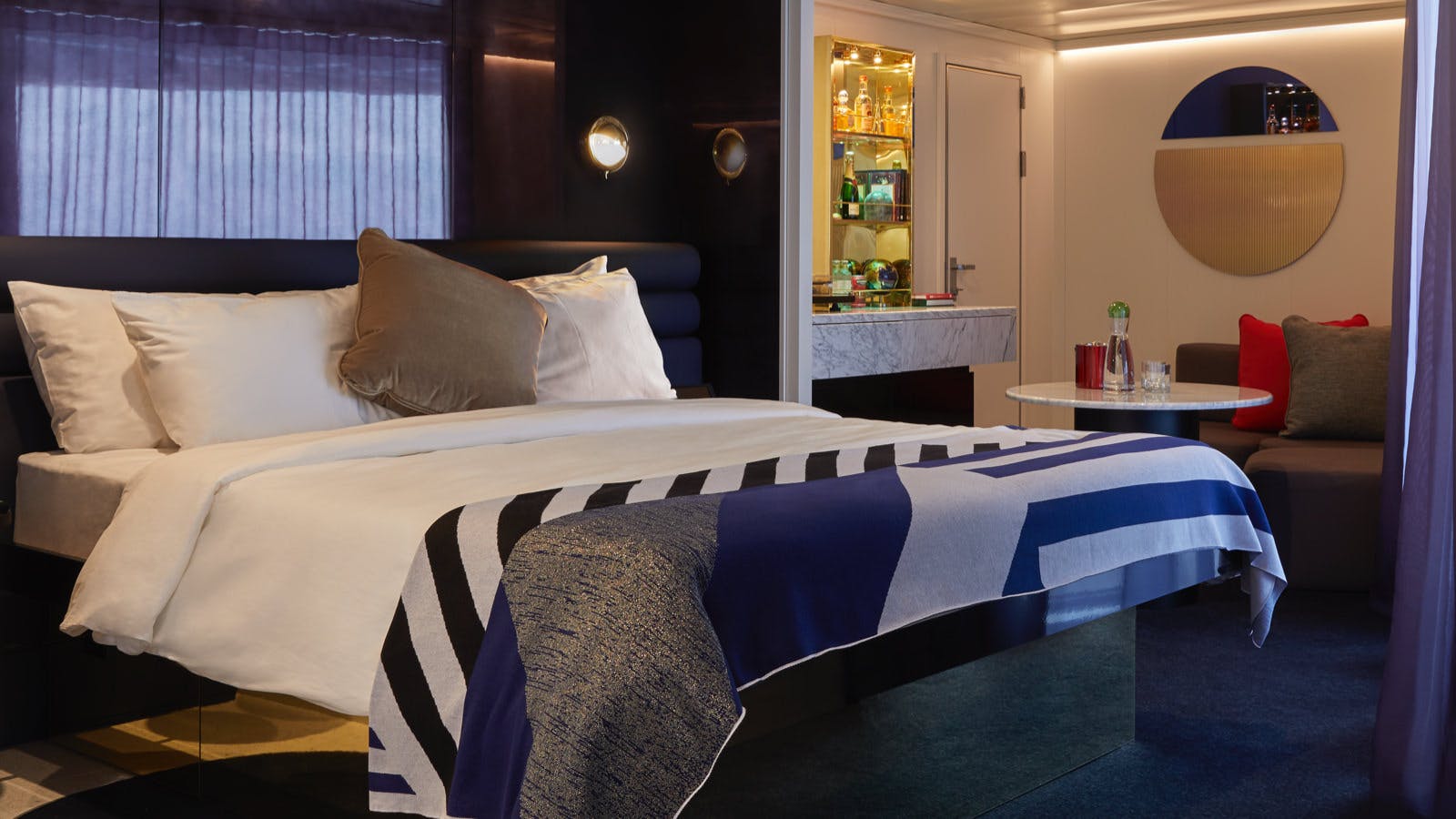 Cheeky Corner Suite bedroom with a curved sofa and ocean views